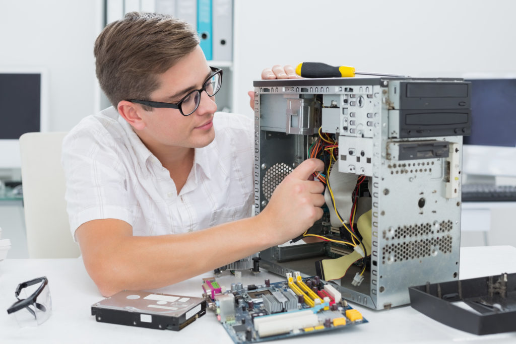 young technician working broken computer scaled